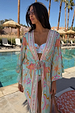 Blue Dreamer Maxi Kimono in light blue with star and heart motifs, styled poolside with a tie waist and tassels.