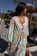 Blue Dreamer Maxi Kimono with colourful sun and heart motifs, featuring a flowy silhouette in a sunny poolside setting.