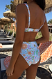 Blue Dreamer High Waist Brief with a sun and palm print, worn by a model in a vacation setting.