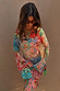 Blue Mari Aria Mesh Dress with a multi-colour paisley print, flared sleeves and a beaded clutch bag.