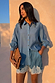 Blue Lace Marley Shirt with white lace detailing on sleeves, styled with matching lace shorts and a patterned clutch.