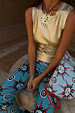 Blue Sun Foldover Trouser with sun motifs, styled with a gold metallic top and matching hand-painted print bag.