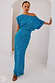 Blue Jacquard Tilly Dress with gold metallic dots and an off-the-shoulder silhouette leaning against a white archway.