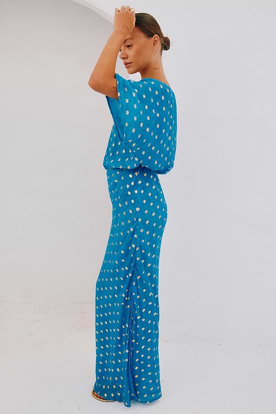 Blue Jacquard Tilly Dress with gold metallic dots and an off-the-shoulder silhouette, shown on a model from the side.
