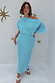 Turquoise Tilly Dress in light blue plisse with gold flecks and a lettuce hem, styled off-the-shoulder.