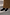 Thumbnail for Black Leather Boots with gold studs and a square toe, styled with a textured camel skirt on white steps.
