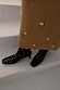 Black Leather Boots with gold studs and a square toe, styled with a textured camel skirt on white steps.