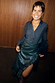 Bottle Green Vegan Leather Ruffle Jaspre Skirt with a multi-wear wrap design, styled with a matching shirt on a smiling model.