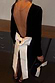 Thumbnail for Black Velvet Bow Mini Dress featuring a deep open back and large detachable cream bow, designed in London.