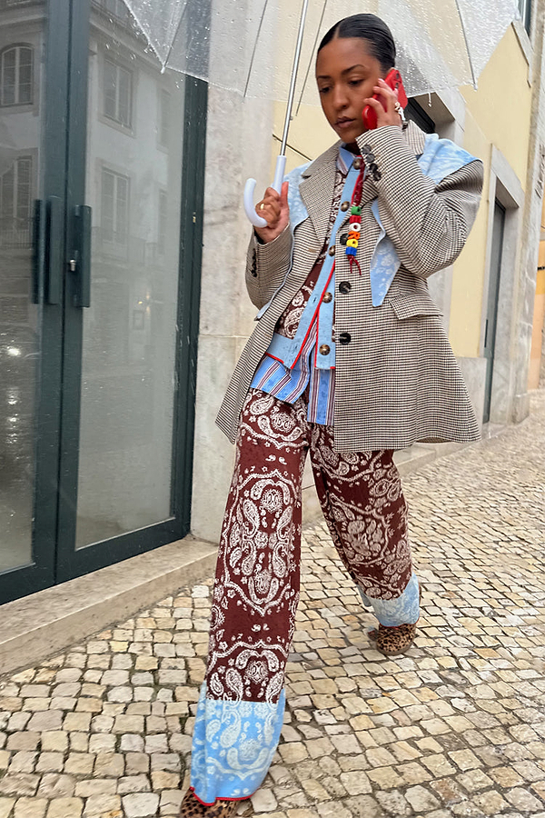 Chocolate Bandana Wide Leg knit trousers with a blue hem, paired with a check blazer on a cobblestone street.