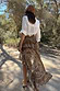 Brown Bandana Cassie Skirt with a white paisley print and ruffled high-low hem, styled in a sunny outdoor setting.