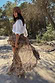 Brown Bandana Cassie Skirt with a white paisley print and tiered ruffles, styled with a white shirt in an outdoor setting.