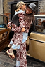 Thumbnail for NFD Kids Chocolate Bandana Knitted Set in brown and blue paisley, worn by a child being carried on a London street.