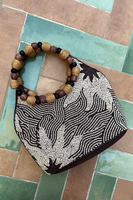 Soleil Beaded Bag featuring chocolate and cream sun print beading and circular raffia and wooden bead handles.