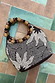 Soleil Beaded Bag featuring chocolate and cream sun print beading and circular raffia and wooden bead handles.