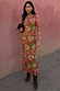 Olive Buckles Mesh Dress with western horseshoe motifs and long sleeves, styled with brown boots and a neck scarf.