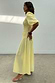 Butter Yellow Shirred Nara Dress with puff sleeves and a pleated skirt, shown on a model from the side.