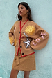 Tan Suede Mini Jaspre Skirt styled with an embroidered camel cardigan and red trim.