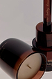 Amber glass NFD Eau De Parfum Candle 001 featuring gold script branding and a visible wick.