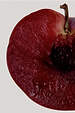 Deep red sliced plum with a dark stone, highlighting a key fragrance note for the NFD Candle 001.