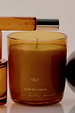 NFD Scent 002 Candle in an amber glass jar with gold lettering, paired with the matching perfume bottle.