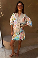White Dreamer Astrid Cardigan with colourful sun and palm motifs, worn with a matching beaded mini skirt.