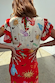 Red Celestial Midi Dress featuring a tie neck detail, ruffled sleeves and iconic sun and palm motifs on soft touch viscose.