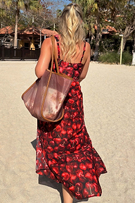 Black Cherry Sarong with a red cherry print and wrap tie waist, worn by a model on a sandy beach vacation.