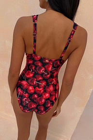Black Cherry Plunge Suit featuring an all-over red cherry print and adjustable straps, shown from the back.