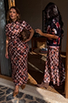 Two models wearing the Check Floral Lottie Skirt in chocolate brown, highlighting the inclusive sizing and midi length.