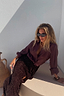 Model wearing the iconic Chocolate Sequin Jaspre Skirt with a matching brown shirt and sunglasses.