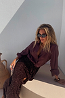 Model wearing the iconic Chocolate Sequin Jaspre Skirt with a matching brown shirt and sunglasses.
