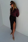 Chocolate sequin Jaspre skirt with a wrap waist and side slit, paired with a dark brown shirt.