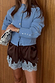 Chocolate satin shorts with ice blue lace trim, styled with a light blue studded cardigan and printed clutch.