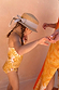 Girl's Yellow Sun Swimsuit with a sun print and frill detailing, designed in London and styled with a straw hat.