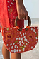 Coral Fawn Beaded Bag featuring glass bead poppy motifs and a wooden handle, paired with a matching coral lace dress.