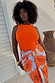 Hot Coral Ribbed Tank in coral orange with a floral wrap skirt, shown on a size UK 18 model for inclusive sizing.