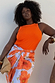 Hot Coral Ribbed Tank in stretch fabric, styled with a floral wrap skirt on a curve model for inclusive sizing.