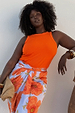 Hot Coral Ribbed Tank in stretch fabric, styled with a floral wrap skirt on a curve model for inclusive sizing.