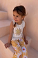 NFD Kids Yellow Sun Cotton Set with a cream sequin sun vest and matching printed trousers on a young girl.