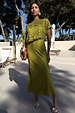 Green Shell Crochet Tilly Dress with a shell-embellished crochet top and satin skirt, styled for a sunny vacation.