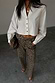 White Cropped Cotton Miley Shirt with blouson sleeves and tortoise buttons, paired with leopard print trousers.