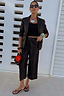 Black Vegan Leather Culottes with a wide leg and crease detail, paired with a matching blazer and black sandals.