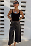 Black Vegan Leather Culottes in a wide-leg silhouette with front crease detailing, styled with a black tank top.