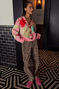 Pink Dallas Cardigan with abstract cowboy motifs and striped trim, styled with leopard print trousers.