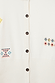Thumbnail for Cream Neon Embroidered Darcy Cardigan detail showcasing colourful geometric motifs and dark button fastenings.