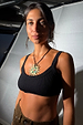 Deloris Sun Necklace featuring a brass sunburst pendant with semi-precious stones on a black leather cord tie.