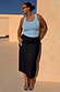 Dark blue denim pencil midi skirt and light blue eyelet vest, designed in London and showcasing inclusive sizing.