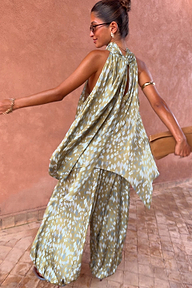 Olive green diamond print halter top with a draped back and asymmetric hem, styled with matching co-ord trousers.