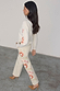 Ecru Enchanted Cut Work Scallop Jeans with colourful sun embroidery and a wide leg, styled with a matching cream cardigan.